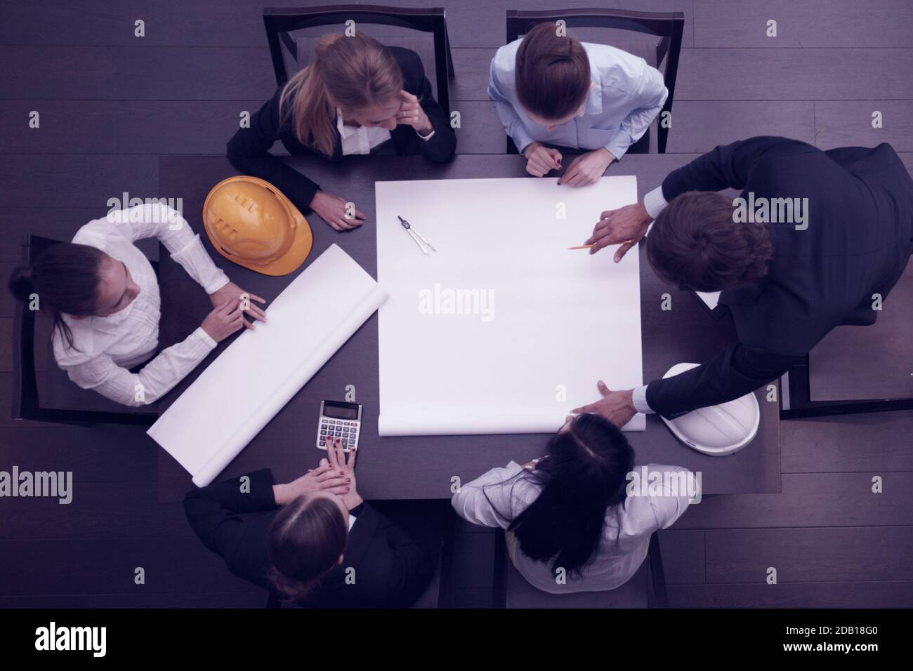 Draufsicht über die Menschen rund um den Tisch in Bauunternehmertreffen leeres Blueprint mit Platz für Text Stockfoto