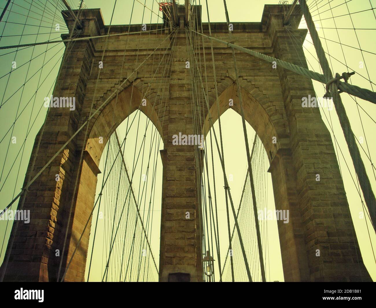 Detail eines der neogotischen Kalksteintürme mit den abgehängten Kabeln der Brooklyn Bridge, dem berühmten Wahrzeichen von New York am East River. Stockfoto