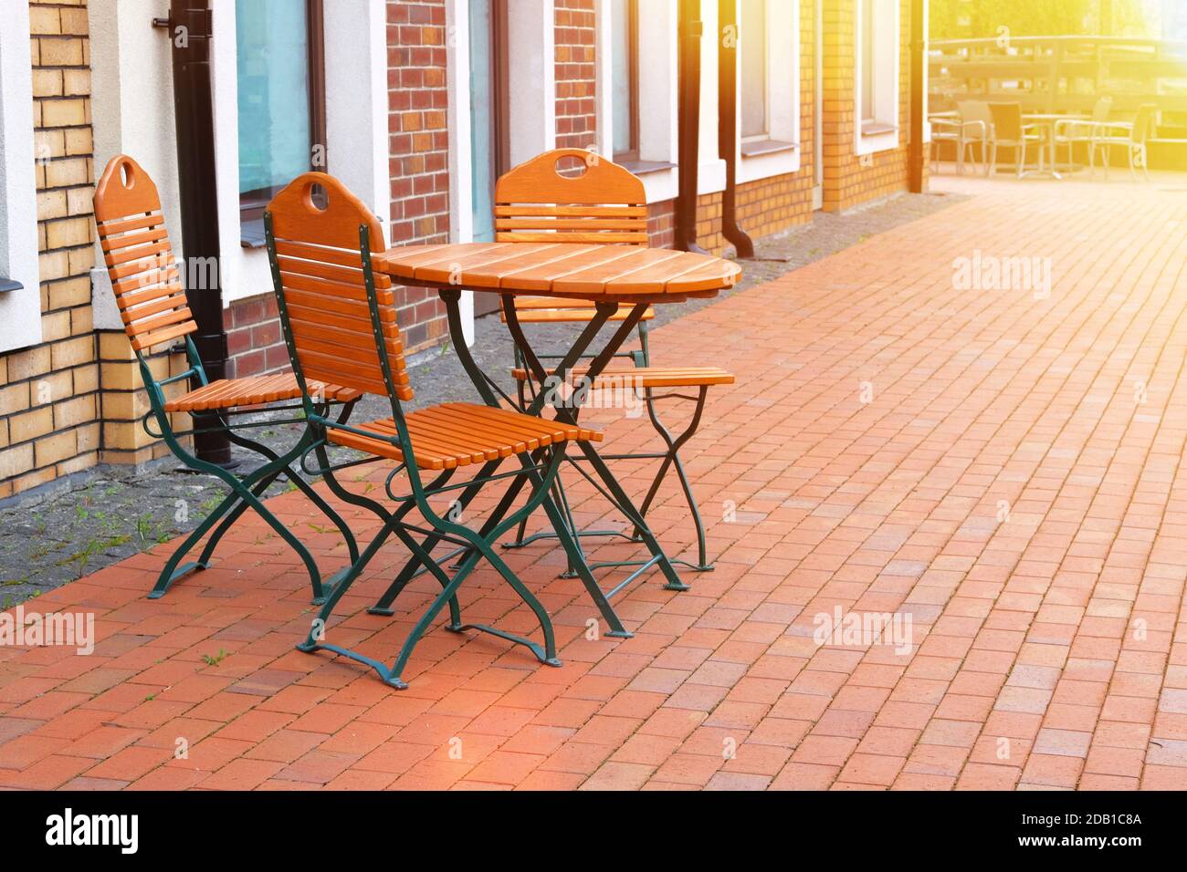Stühle und Tische im Restaurant im Freien mit Holzplatten. Terrasse in der Stadt im Sommer. So. Stockfoto