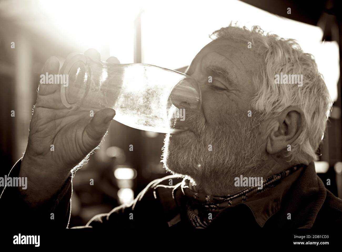 Älterer Mann, der den letzten Tropfen Bier aus einem Glas entwässert, England Stockfoto