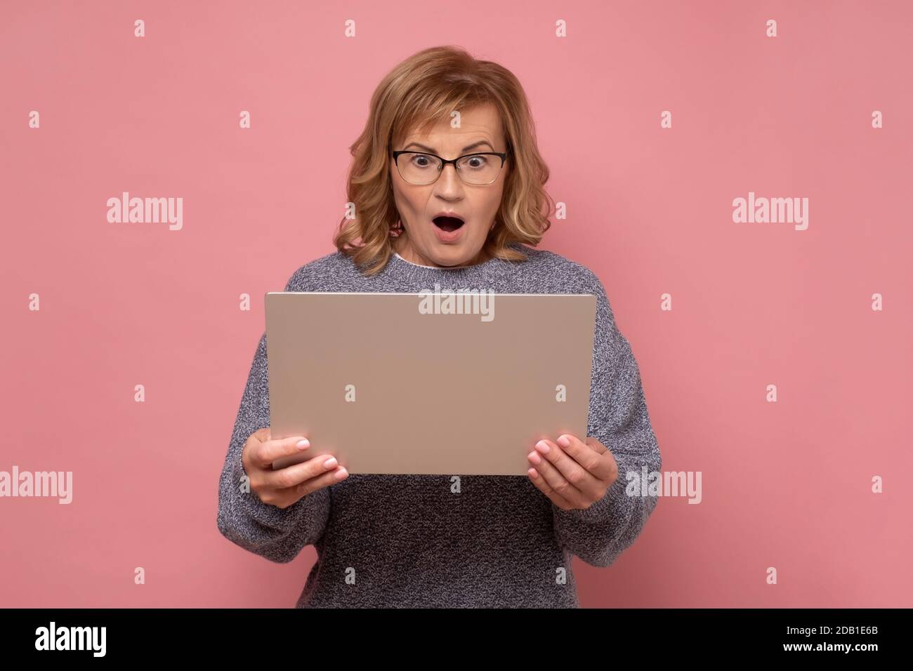 Reifen kaukasischen Mann hält Laptop suchen mit Erstaunen und Schock, mit Computer. Stockfoto