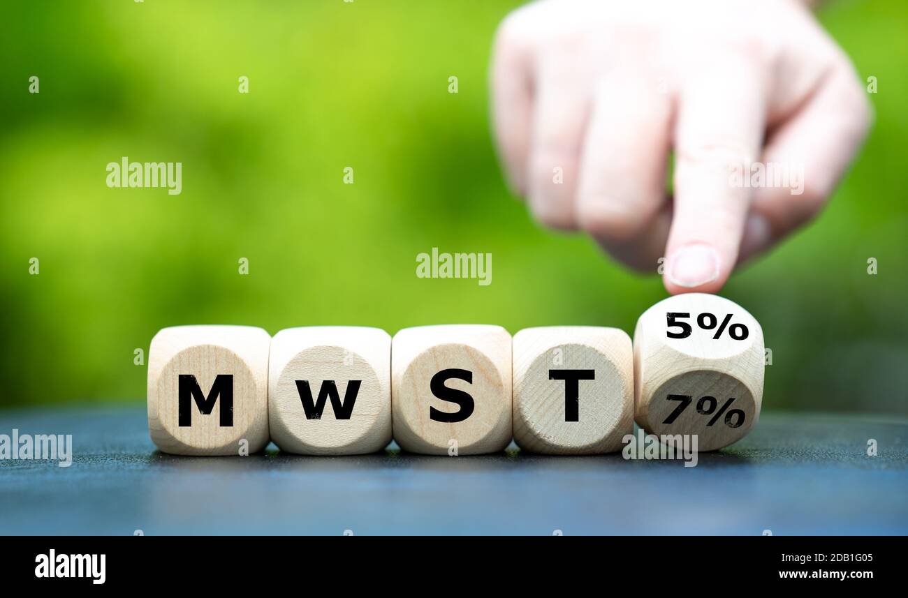 Ende der deutschen Konjunkturpakete im Januar 2021. Hand dreht Würfel und ändert den Ausdruck 'MWST 5%' ('Mehrwertsteuer 5%') in 'MWST 7%' ('Wert Stockfoto