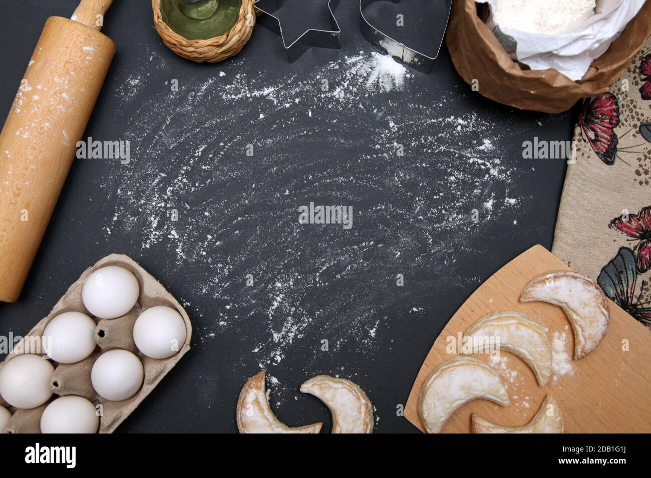 Backhintergrund mit Schneidebrett, Ei, Brot, Mehl, Nudelholz. Stockfoto