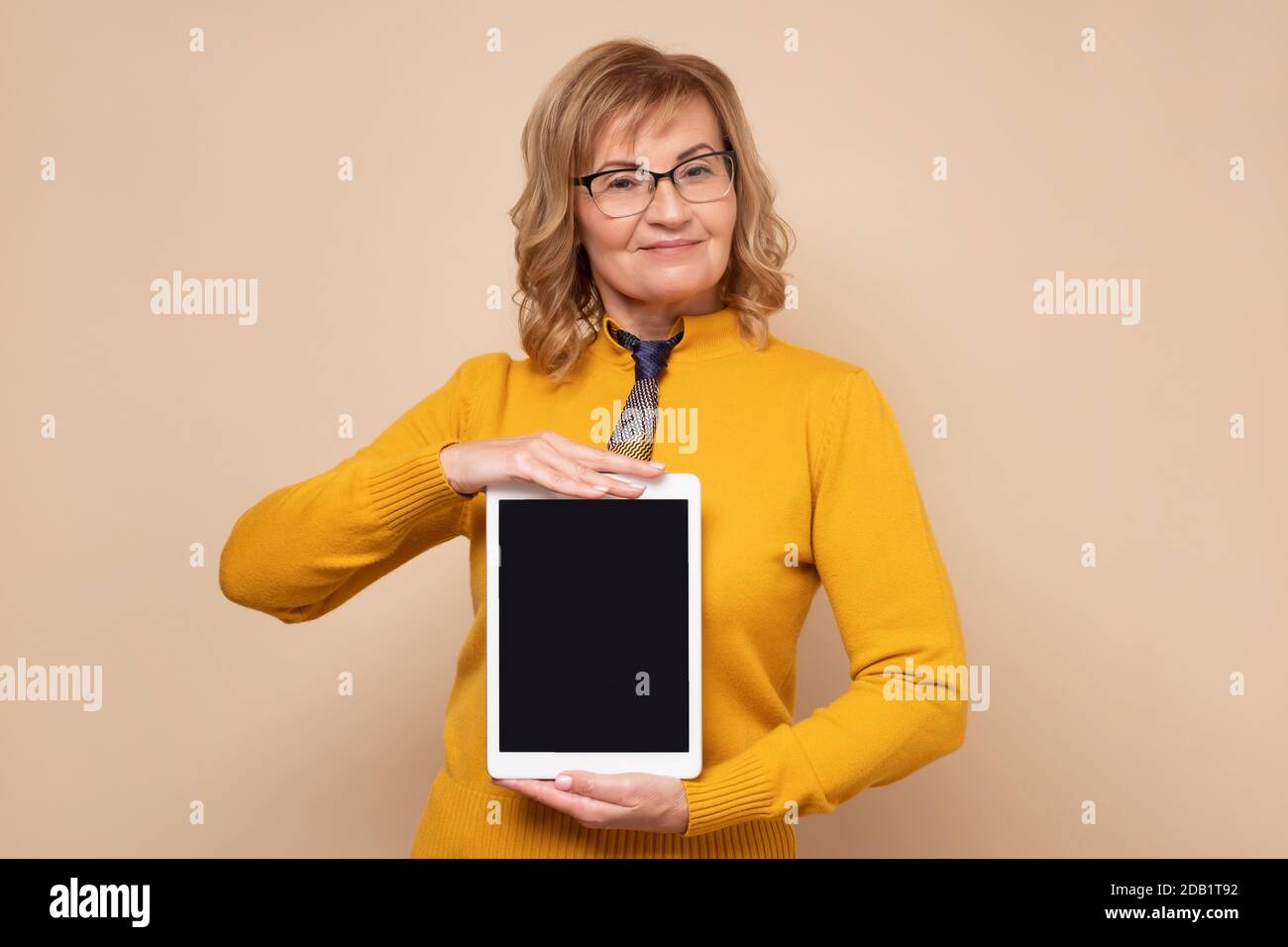 Senior Office Frau zeigt leeren Tablet-Bildschirm mit Copyspace Stockfoto