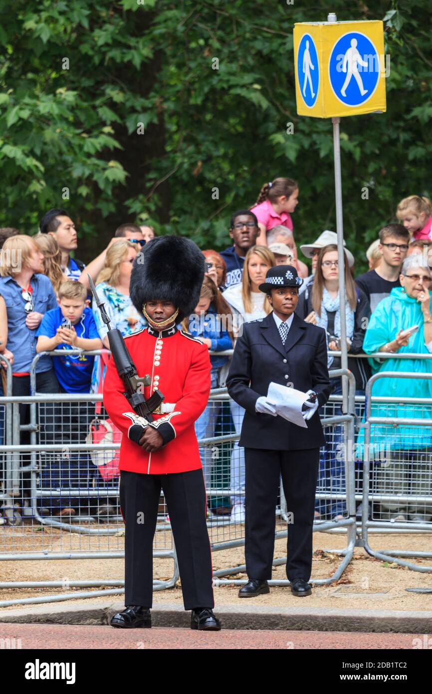 Ethnische Minderheit Grenadier Fußwächter Soldat und Polizistin bei Trooping the Color Parade, London, England, Großbritannien Stockfoto