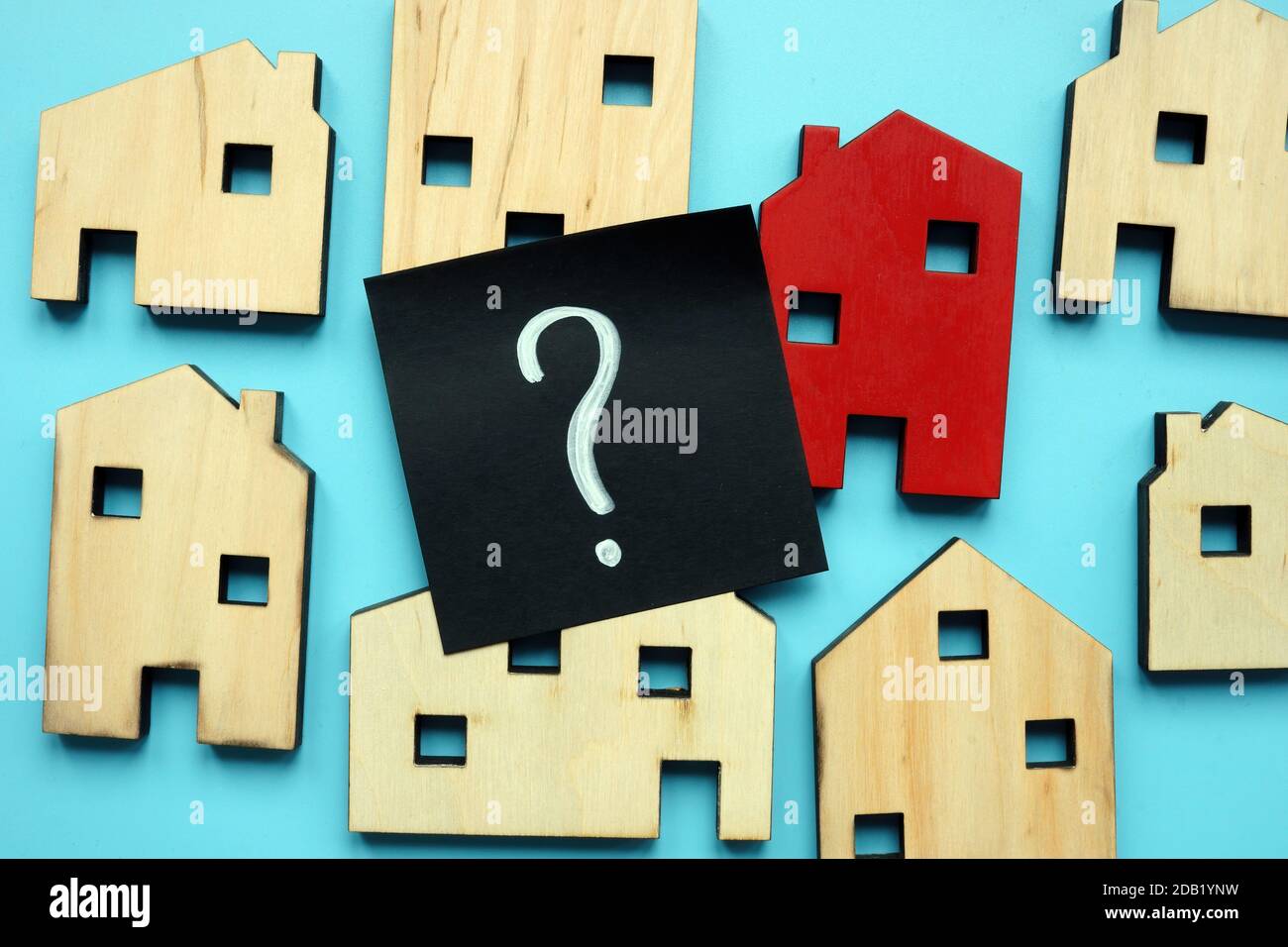 Winzige Häuser und Fragezeichen. Eigenheimbewertung und -Auswahl. Stockfoto