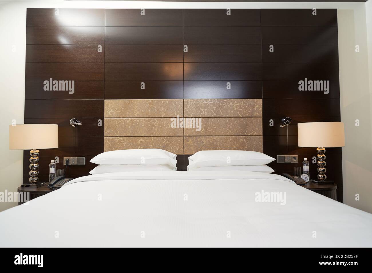 Inneneinrichtung des Hotelapartments mit einem großen Bett und schönen Lampen. Interior Design Konzept Stockfoto