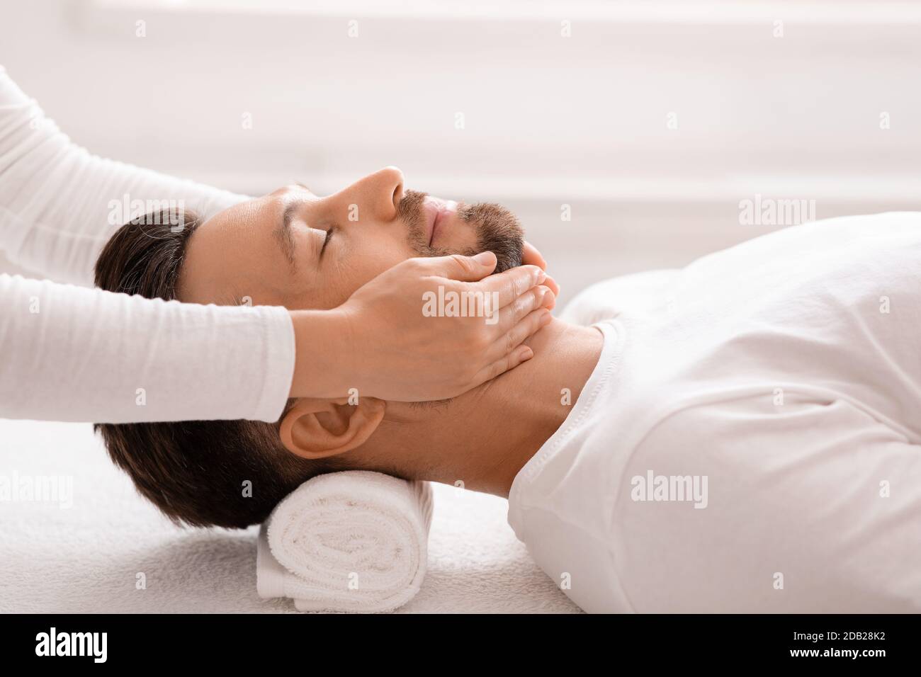 Mann mittleren Alters, der im Spa-Salon war und Gesichtsmassage bekommen hat Stockfoto