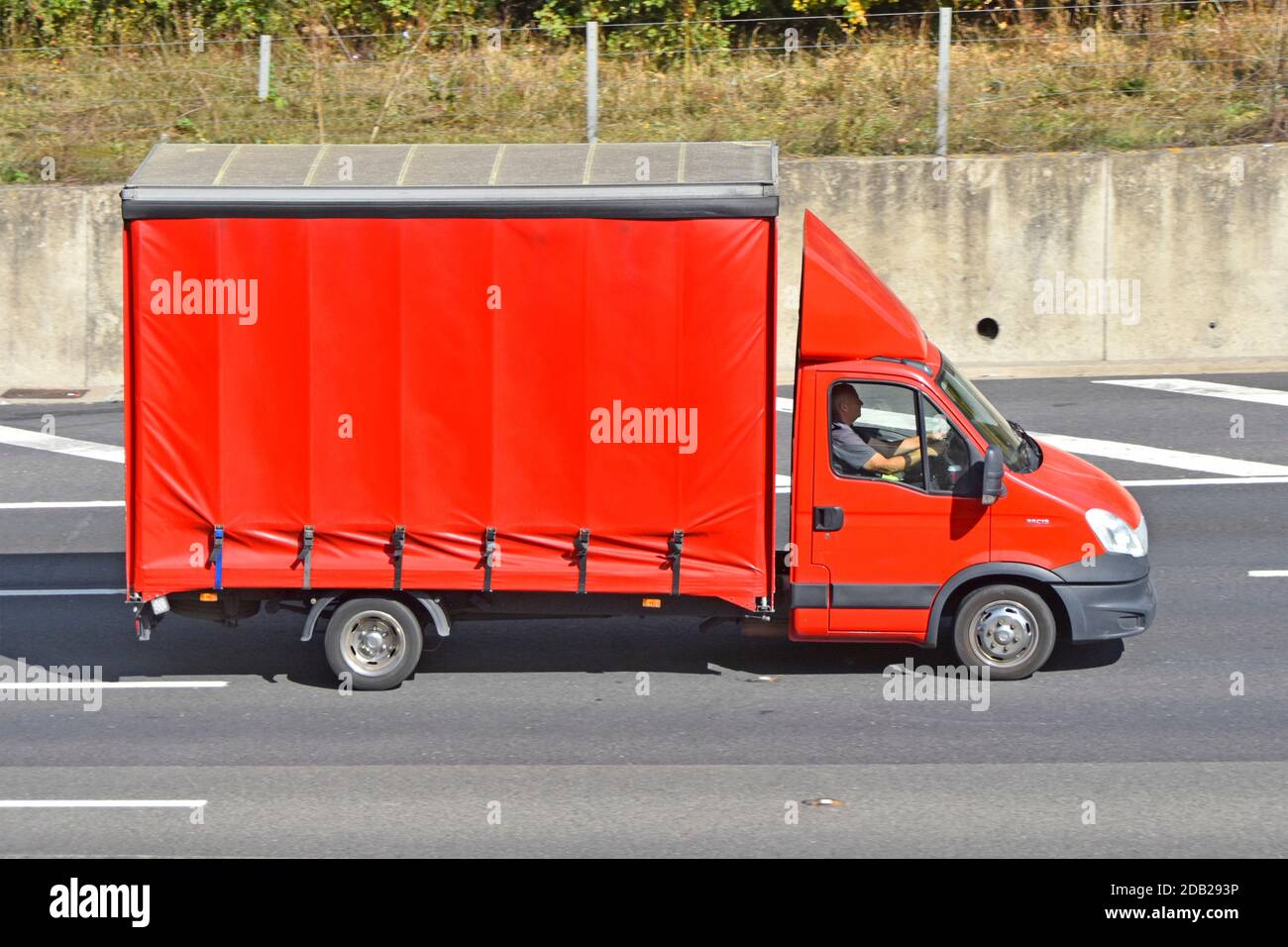 Fahrer- und Seitenansicht, alles rot, weicher Vorhang, Van Karosserie bei Fahrgestellkabine 35C13 mit aerodynamischer Windrichtung über der Kabine Deflektor fährt entlang der britischen Autobahn Stockfoto