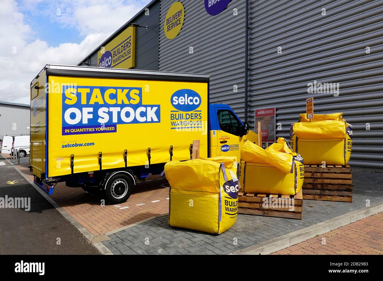 SELCO Bauherren Händler gelb Lieferwagen mit Vorhang seitlichen Zugang Geparkt in Chelmsford Lagerhaus Depot neben fibc Jumbo-Taschen Essex England GB Stockfoto