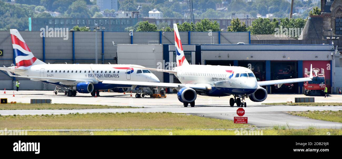 British Airways Flugzeuge ein Rolling am London City Airport Vor dem Feuerwehrgebäude und den Notfallgeräten Newham East London England, Großbritannien Stockfoto