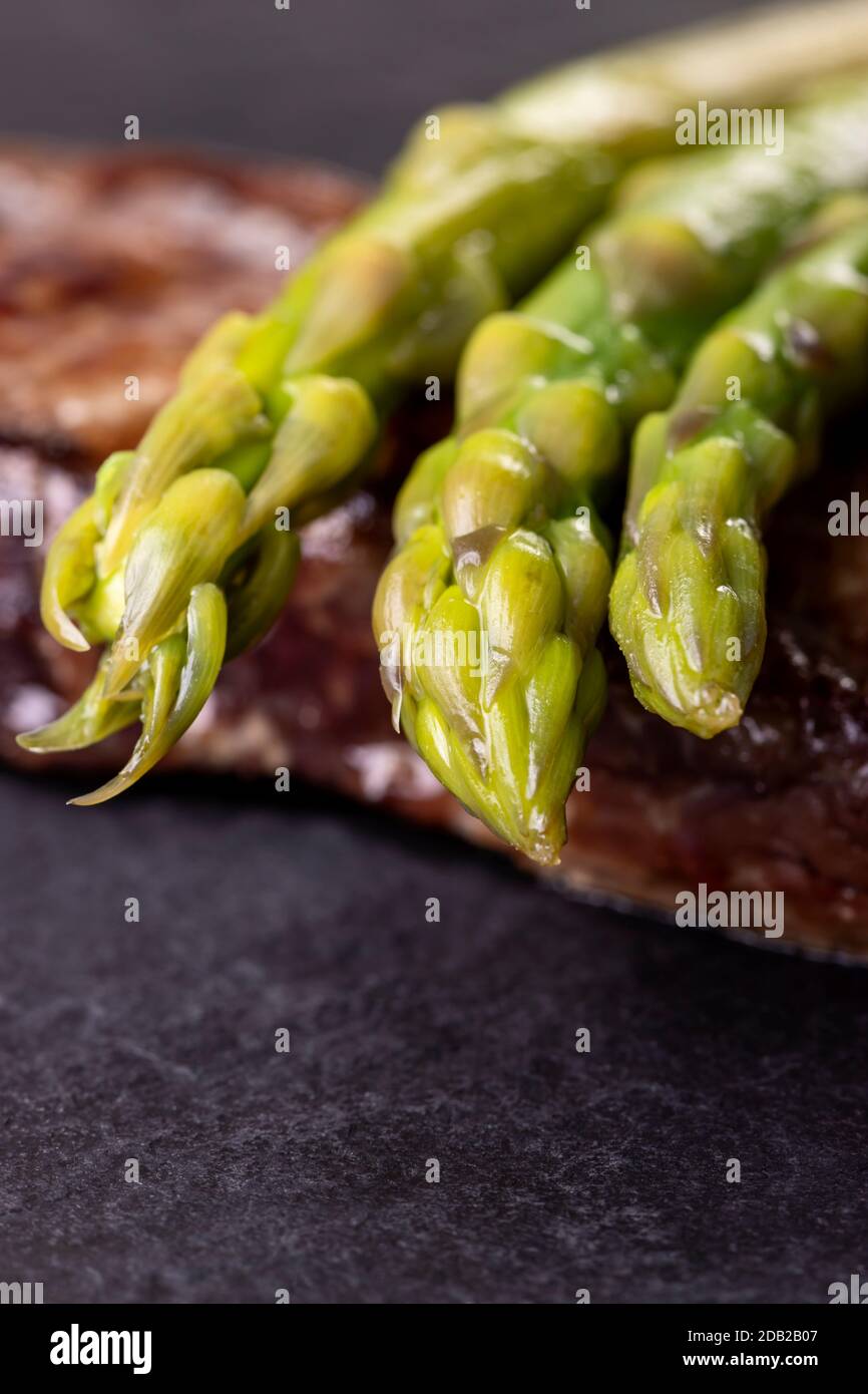 Grüner Spargel auf einem Steak Stockfoto