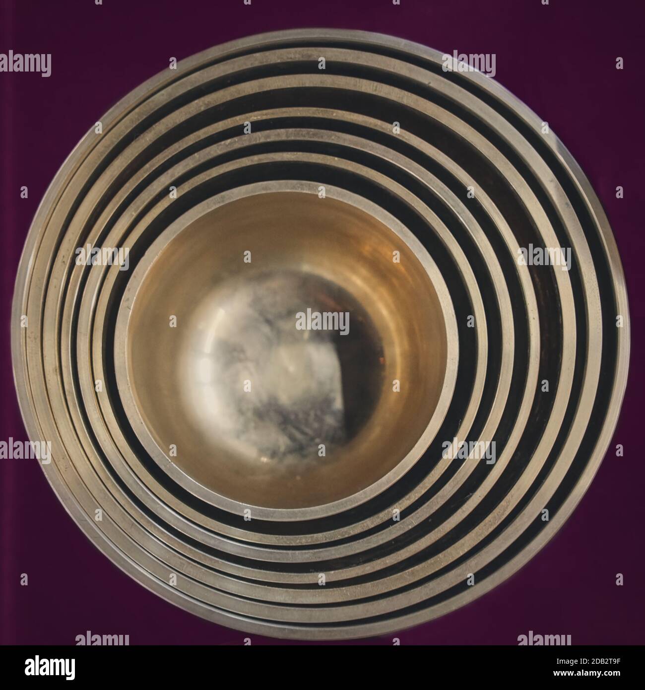 Blick von oben auf eine Reihe von gestapelten tibetischen Gesangsschalen, die ineinander verschachtelt sind. Meditationsinstrument und heilende Musiktherapie zur Entspannung Stockfoto