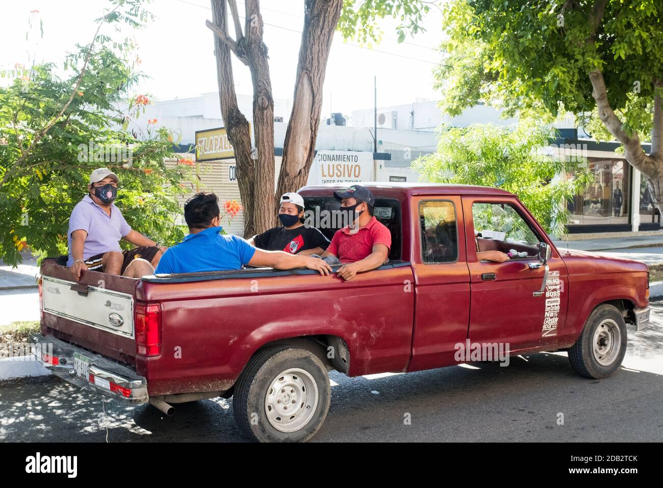 Mexikanische Arbeiter sitzen auf der Rückseite eines LKW, Merida Mexiko Stockfoto