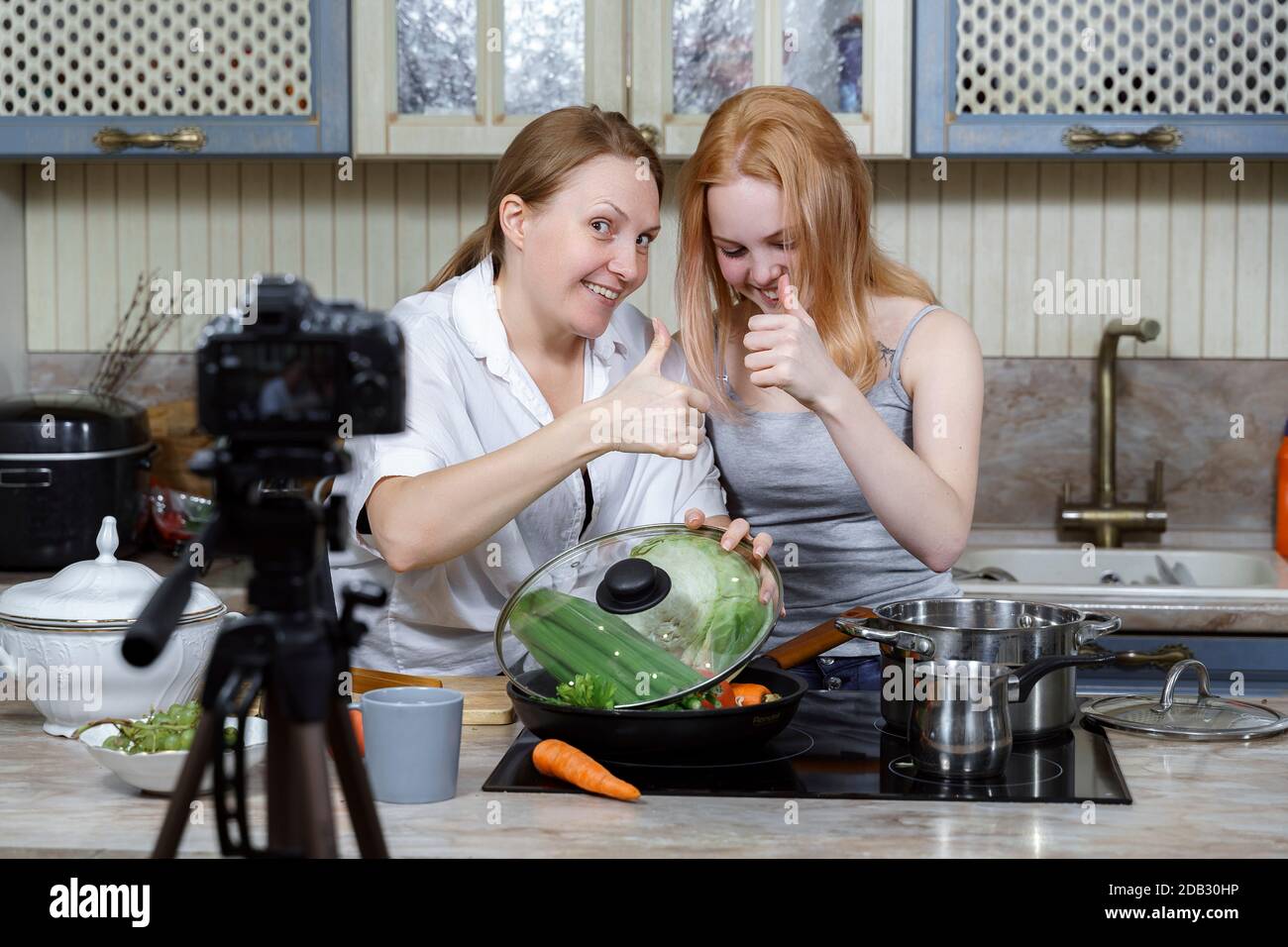 Mama und Tochter sind Aufnahme einer lustigen Koch-Show. Lebensmittel vlogging. Stockfoto