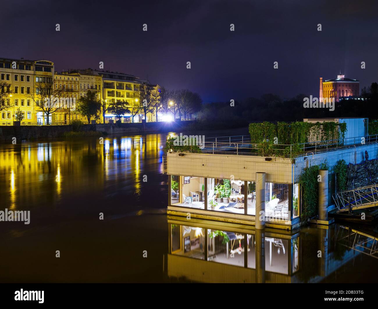 Schwimmende Haus auf einem Fluss in der europäischen Stadt. Nachtszene Stockfoto