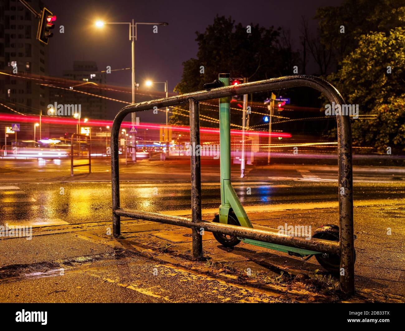 Elektroroller auf einer regnerischen Nacht Stadt Straße Stockfoto