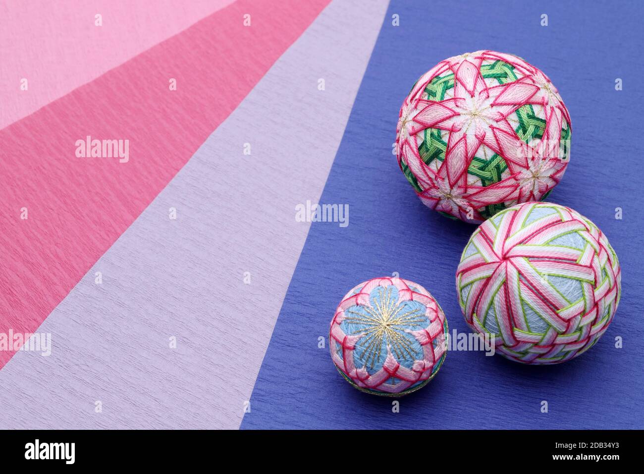 Japanische traditionelle bunte temari-Kugel auf farbigem Papierhintergrund Stockfoto