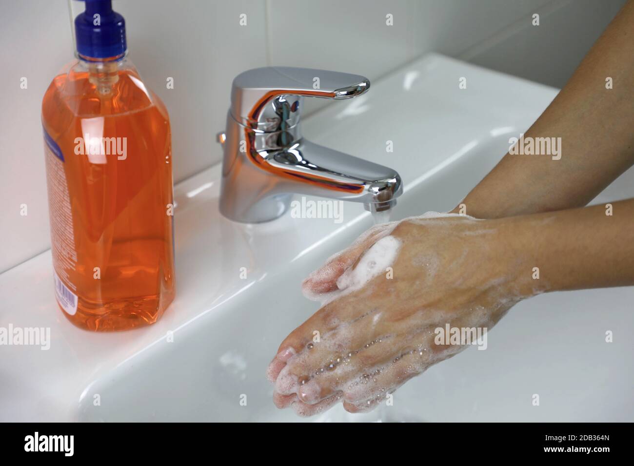 COVID-19 Hygienekonzept. Waschen der Hände mit Seife unter dem Hahn mit Wasser gegen Neuartiges Coronavirus (2019-nCoV). Antiseptikum, Hygiene und Healthcar Stockfoto