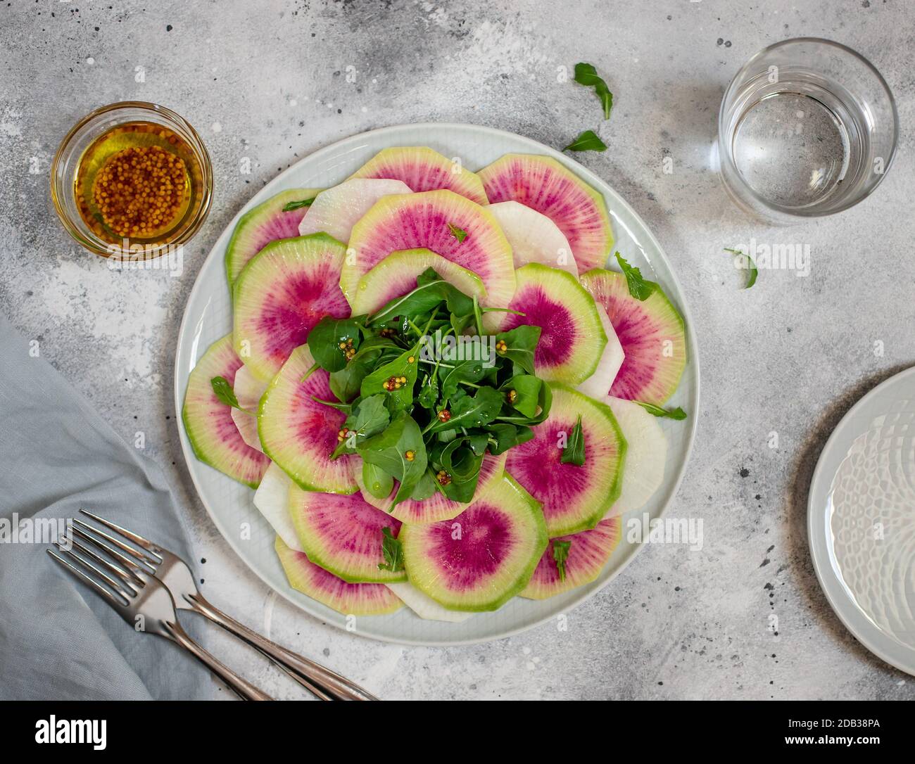 Detox Salat von Wassermelone Rettich und Rucola in einem Teller. Hausgemachte gesunde Lebensmittel. Heller Beton oder Stein Hintergrund. Draufsicht Stockfoto