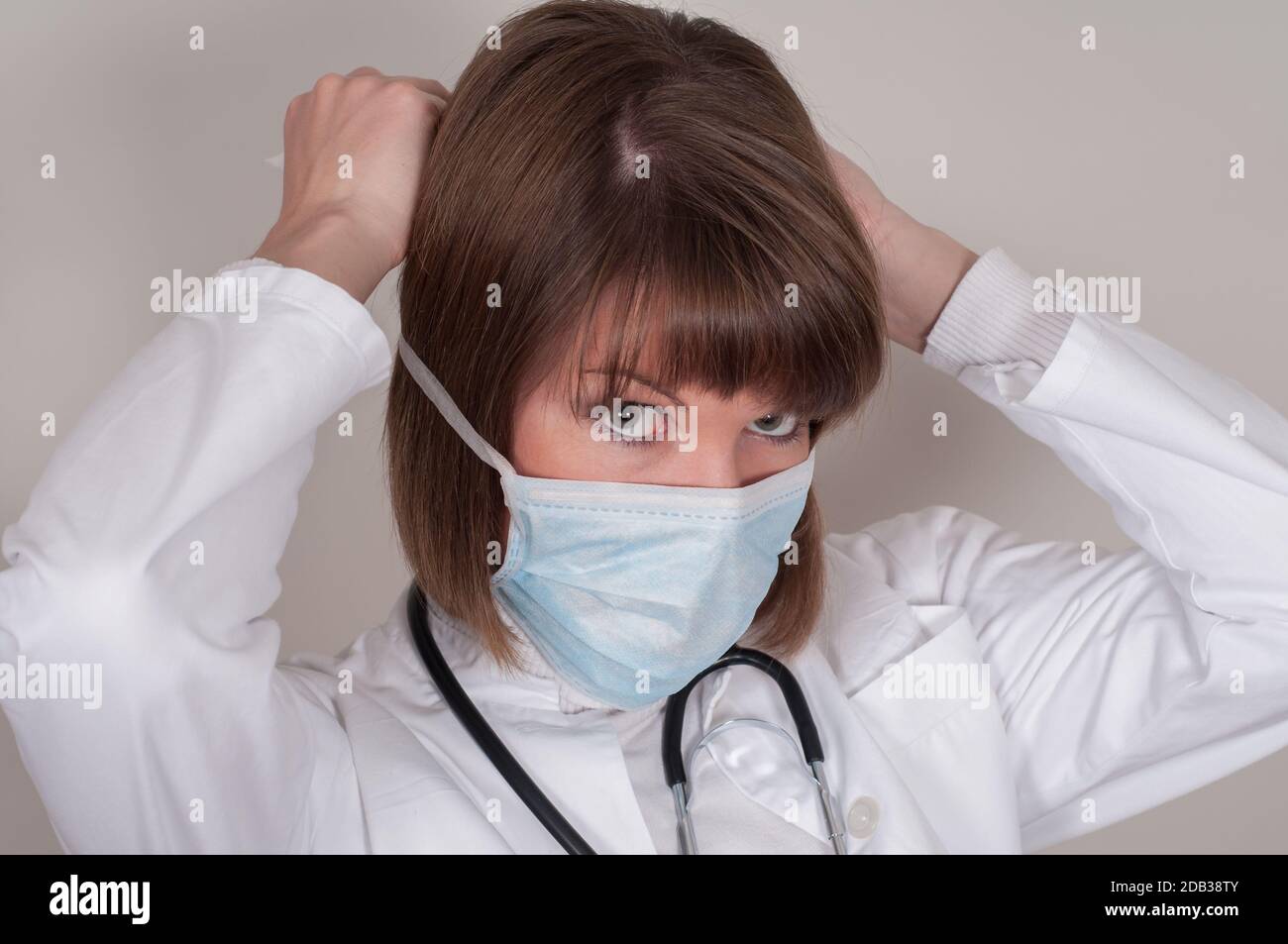 Femle Doctor legt eine Schutzmaske an Stockfoto