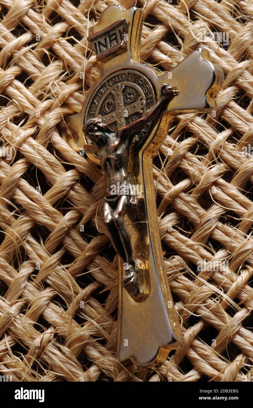 Altes Metallkruzifix auf Strohgrund Stockfoto