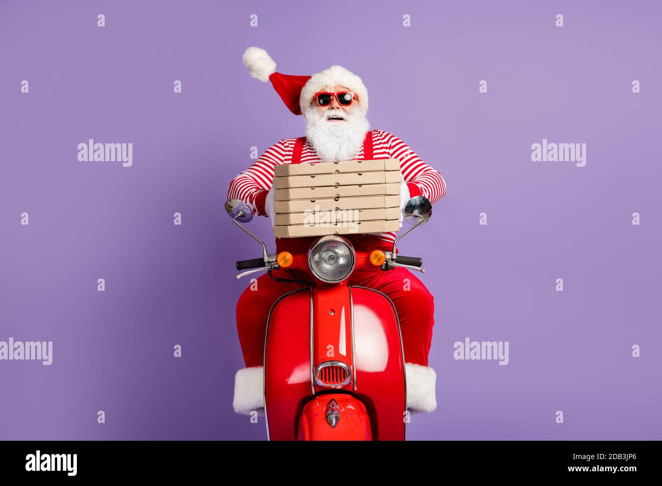 Foto von lustigen santa claus Fahrt schnell Moped halten Pizza Boxen tragen Weihnachtskostüm gestreiftes Hemd Mütze Gläser isoliert violett Farbiger Hintergrund Stockfoto