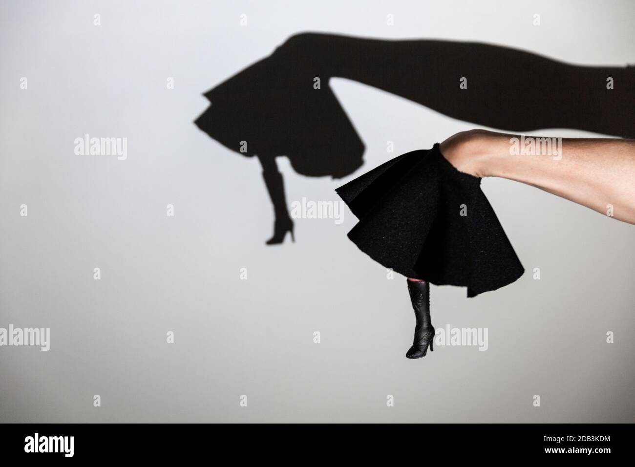 Spielen Schatten projiziert auf eine weiße Leinwand. Die Hände der Person Formen die Beine eines Tänzers in Stiefeln Stockfoto