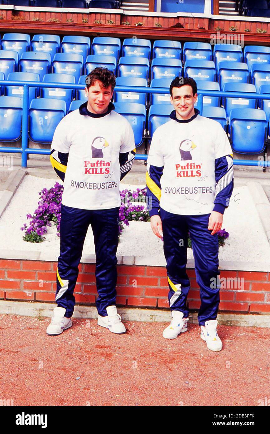 35mm Verbündeter McCoist Paul McStay im Rugby Park Kilmarnock 1986 in der Trainingseinheit gescannt, tragen sie beide T-Shirts, die von lokalen Schulkindern für den NHS entworfen wurden, um die Gefahren des Rauchens hervorzuheben, sagt das T-Shirt Puffin Kills, Smokebuster. Die Fußballer trainieren als Teil der Scottish Squad vor einem Spiel mit Dänemark Stockfoto