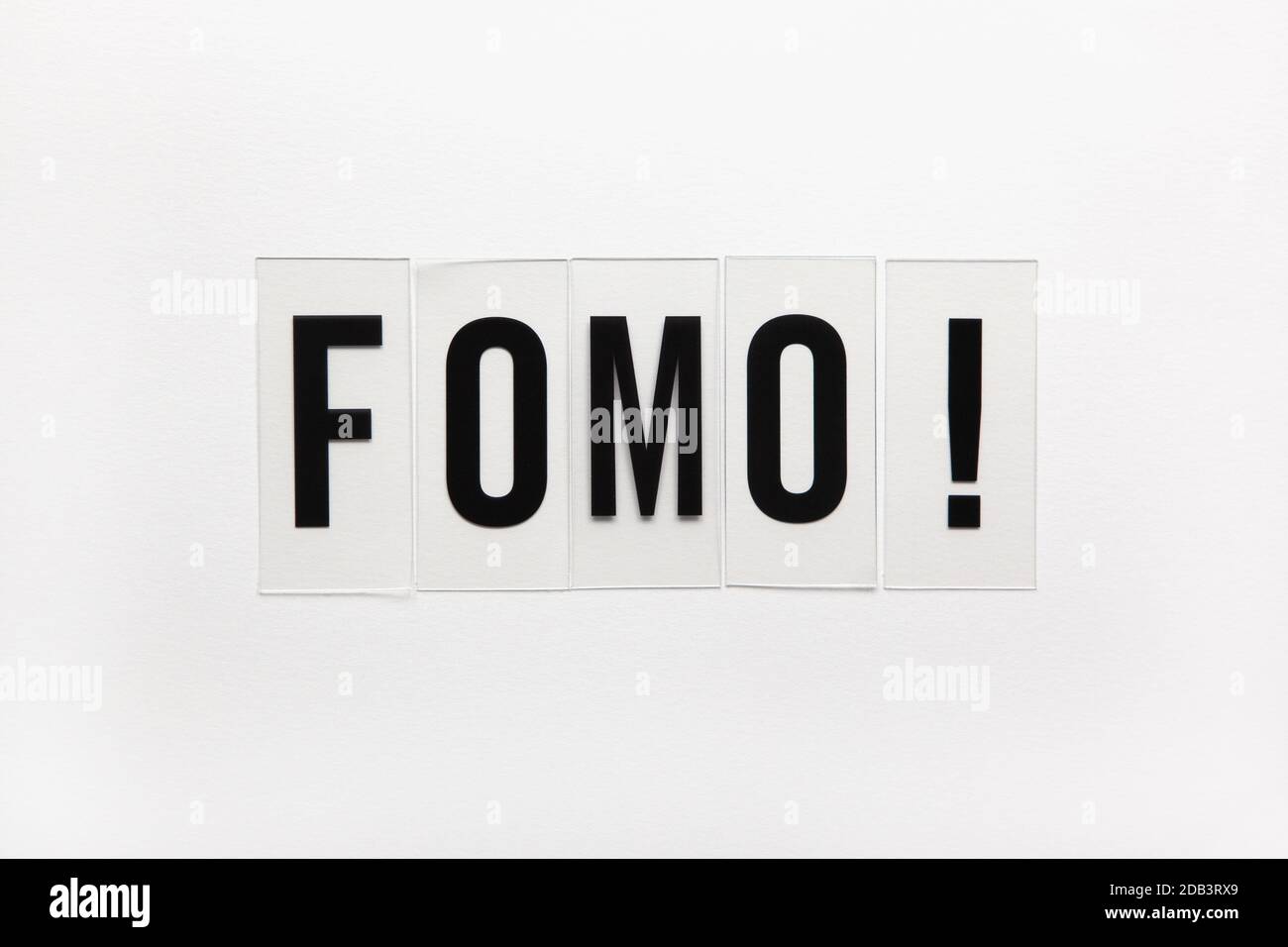 Abkürzung Wort FOMO auf transparentem Kunststoff auf weiß. Es bedeutet Angst vor dem Verfehlen, non-stop Internet-Surfen. Konzept der sozialen Kommunikation Problem Stockfoto