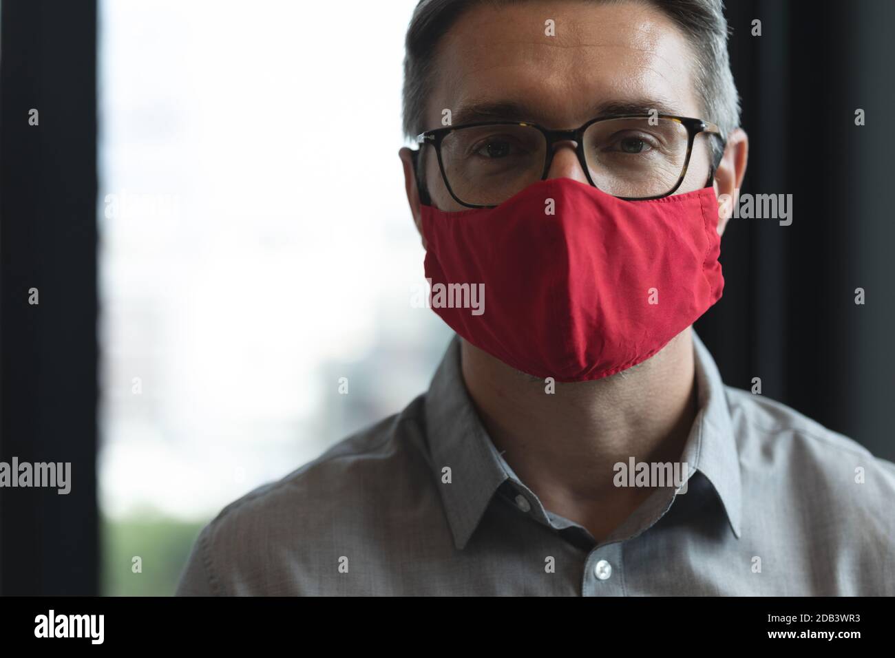 Porträt des kaukasischen Mann trägt Gesichtsmaske im modernen Büro Stockfoto