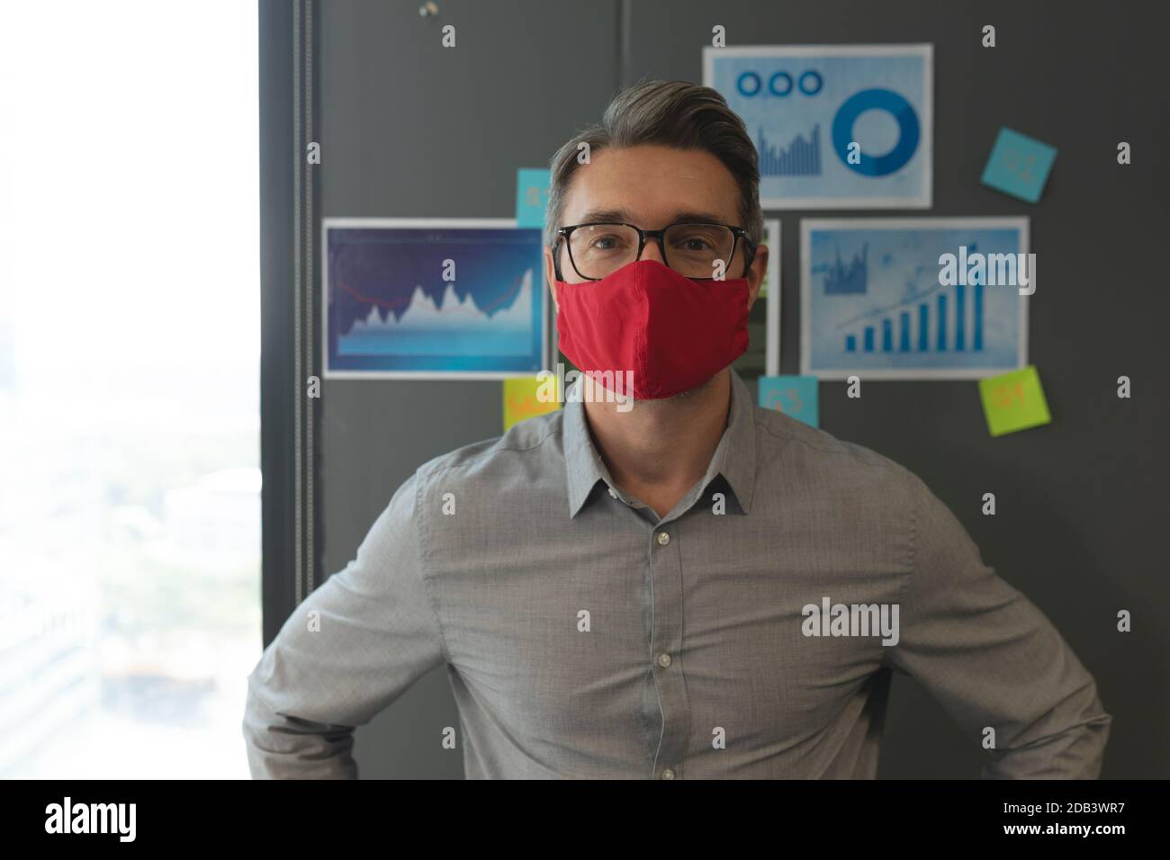 Porträt des kaukasischen Mann trägt Gesichtsmaske im modernen stehen Büro Stockfoto