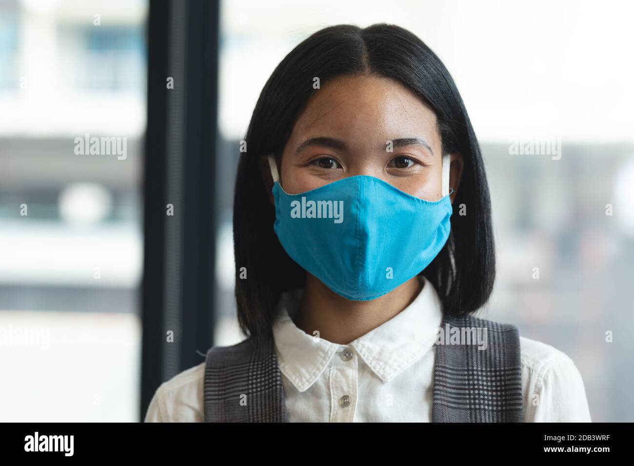 Portrait der asiatischen Frau trägt Gesichtsmaske im modernen Büro Stockfoto