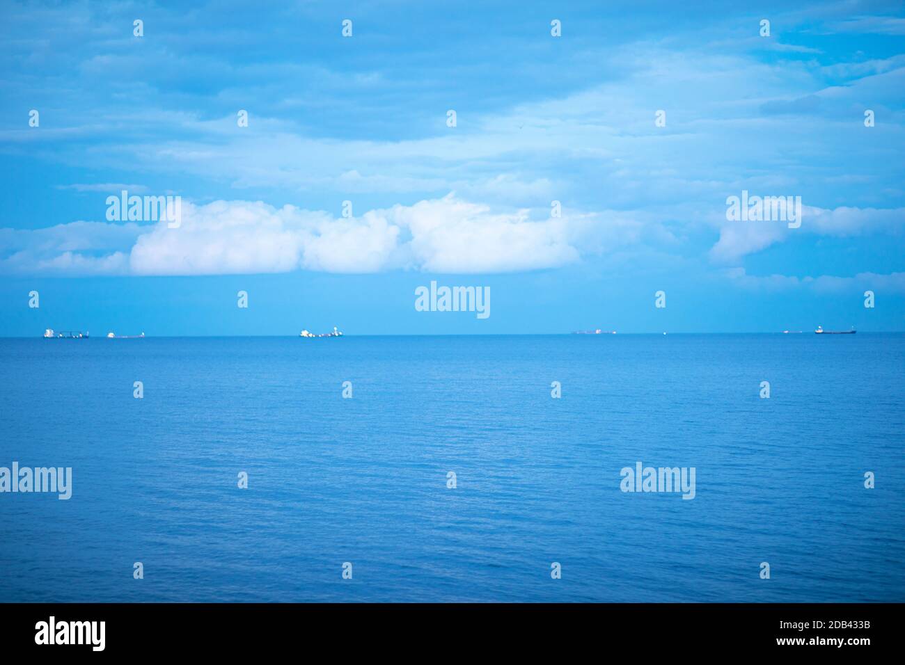 Ruhiges blaues Meer mit Schiffen im Hintergrund. Stockfoto
