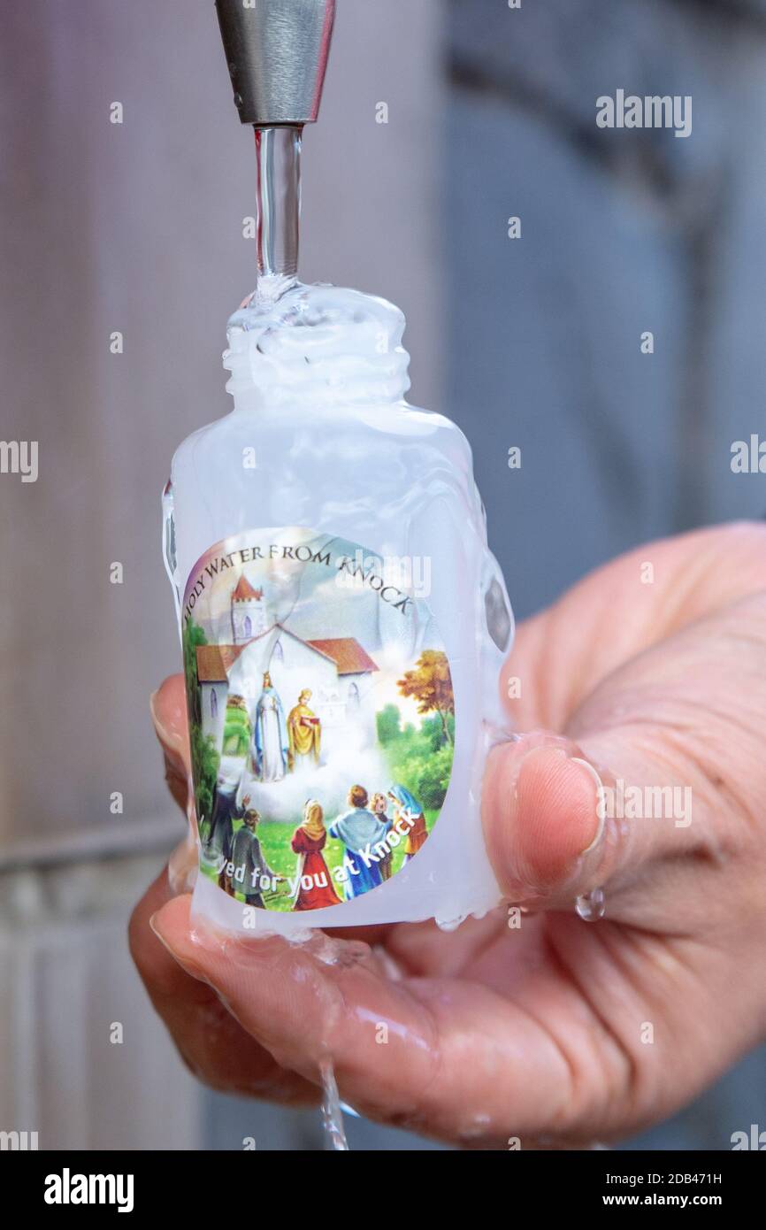 Füllen einer Plastikflasche mit heiligem Wasser bei Irlands National Marienheiligtum in Knock in der Grafschaft Mayo Stockfoto