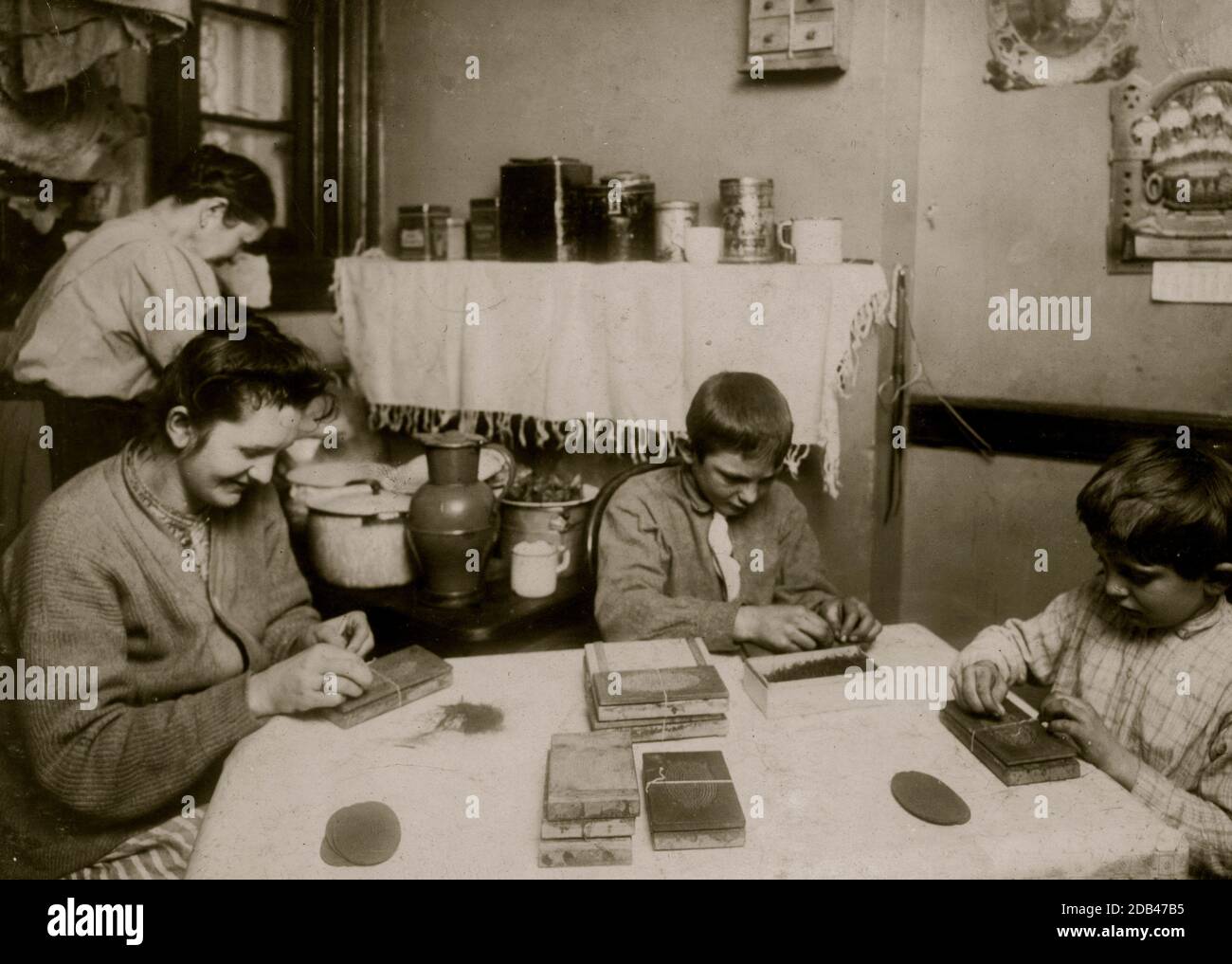 Haarbürsten erstellen. Familie Hausner, 310 E. 71 St., N.Y. Frank ist 6 Jahre alt und John ist 12 Jahre alt. Die Mutter hatte einen Halsschmerzen und trug einen tollen Lappen, der um ihn herum gerupft war, aber sie nahm ihn für das Foto ab. Sie sagten, dass sie alle (einschließlich des 6-jährigen) bis 10 UHR arbeiteten, wenn sie beschäftigt waren. Ihr Nachbar bestätigte dies. Sie sagte: "Es ist viel besser für die Jungs, als nichts zu tun." Die Mutter sagte, dass die Nachtarbeit ihren Augen weh tut und John sagte es auch. Er war nicht sehr begeistert von den Schönheiten der Arbeit. Alles in allem machen sie etwa 2 Dollar pro Woche. Vater ist ein Autofahrer.. Stockfoto