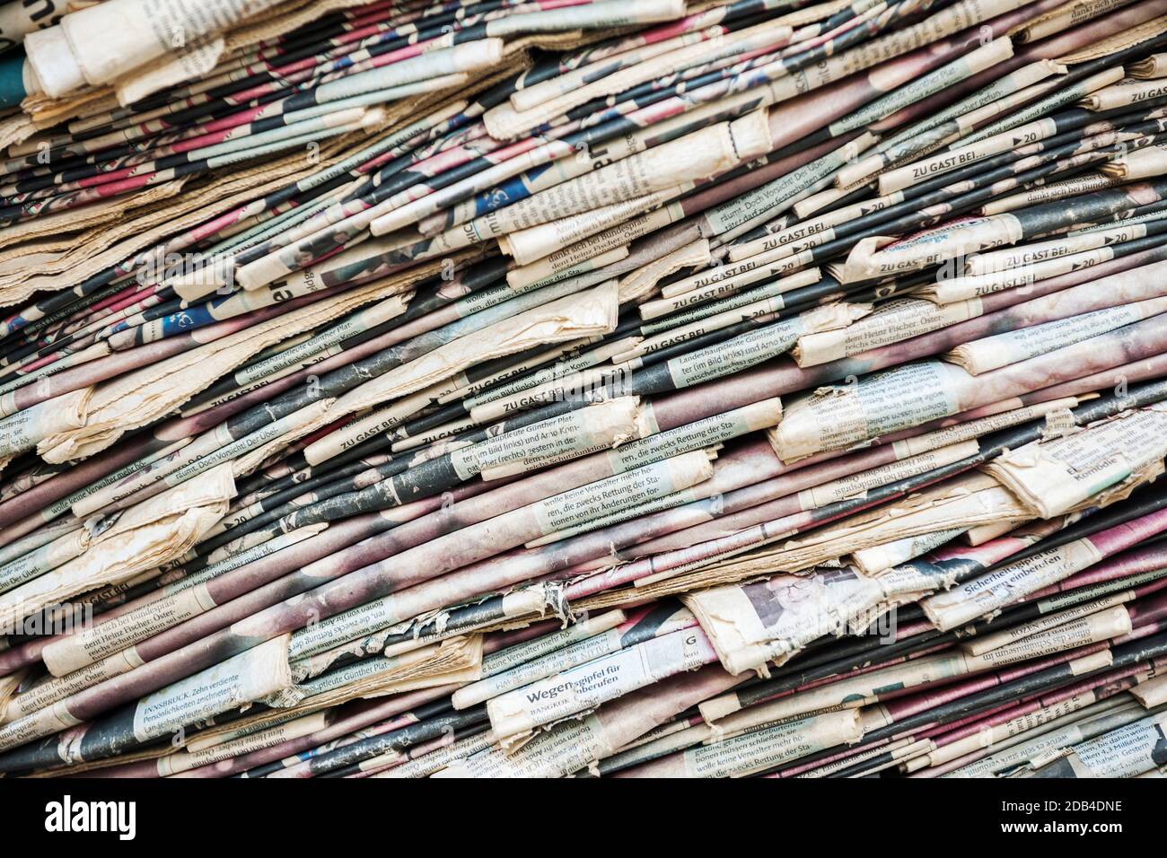 Ganzseitige Ansicht der alten und vergilbten diagonal gestapelten Tageszeitung Stockfoto