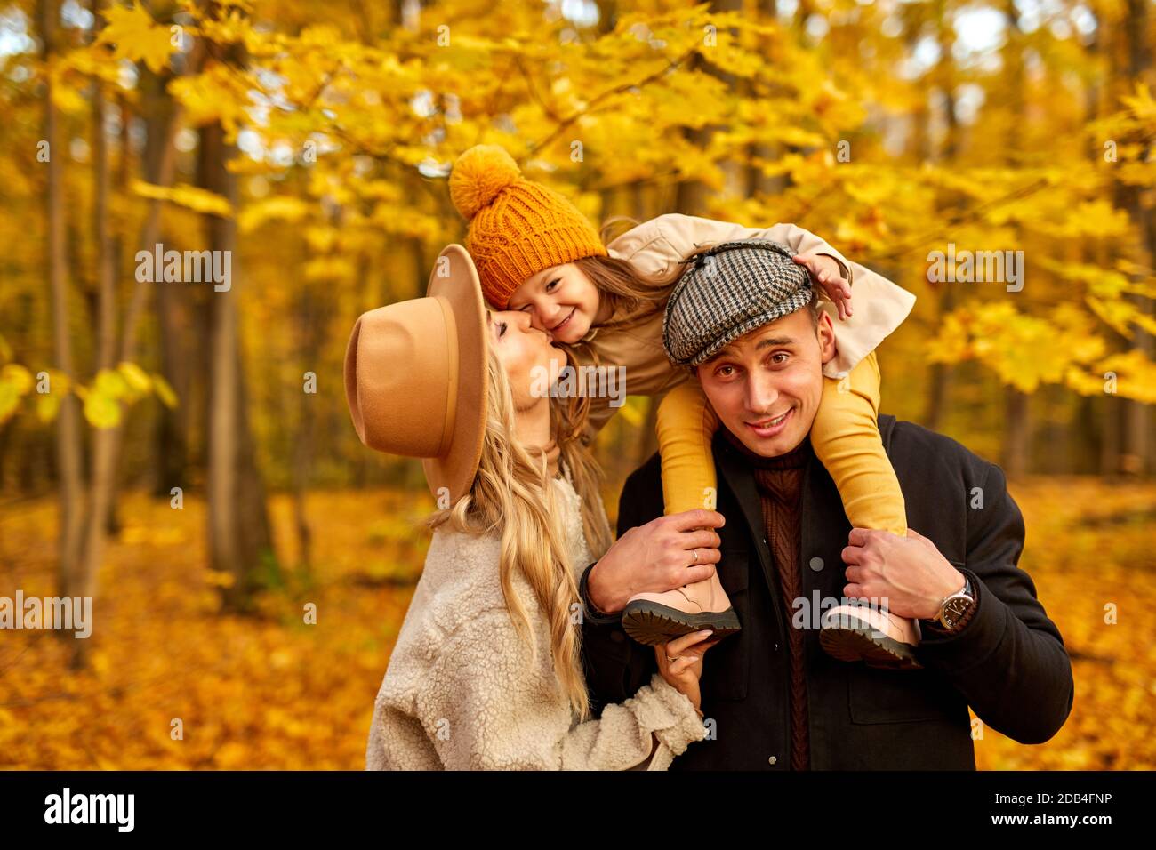 Glückliche Familie haben Spaß im Herbst Park Natur, kaukasischen Paar und Kind umarmt, küssen, zum Ausdruck bringen Liebe zueinander. In Mänteln im Freien Stockfoto