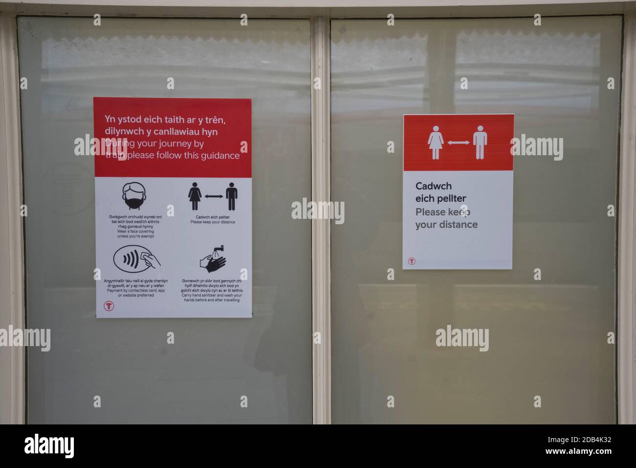 Bahnhof mit zweisprachigen Sicherheitsschildern in Walisisch und Englisch Wegen Coronavirus, Covid-19 Pandemie in Aberystwyth, Ceredigion, Wales, Großbritannien Stockfoto