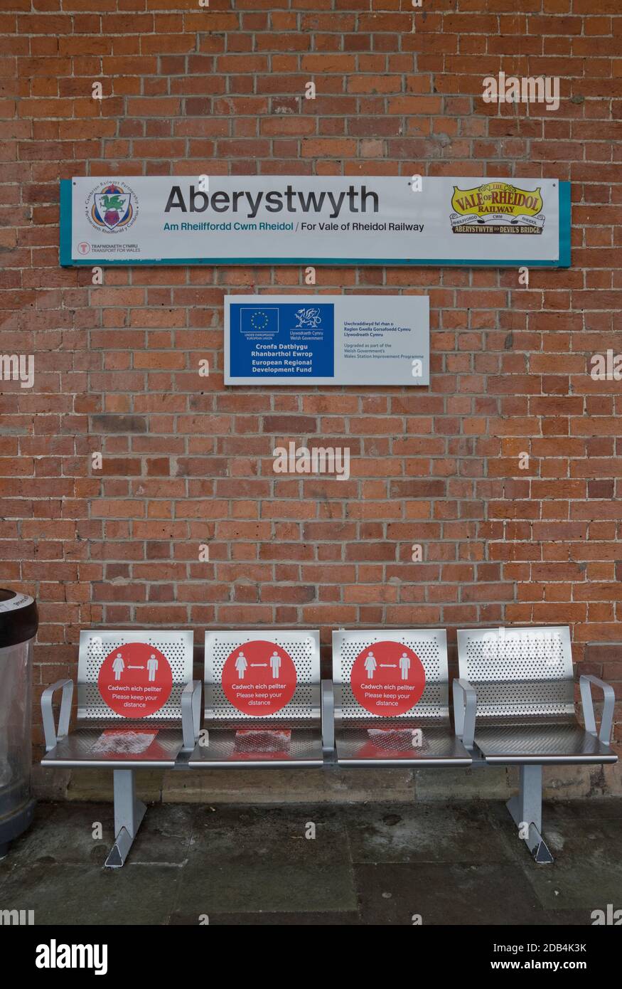 Bahnhof mit zweisprachigen Sicherheitsschildern in Walisisch und Englisch Wegen Coronavirus, Covid-19 Pandemie in Aberystwyth, Ceredigion, Wales, Großbritannien Stockfoto