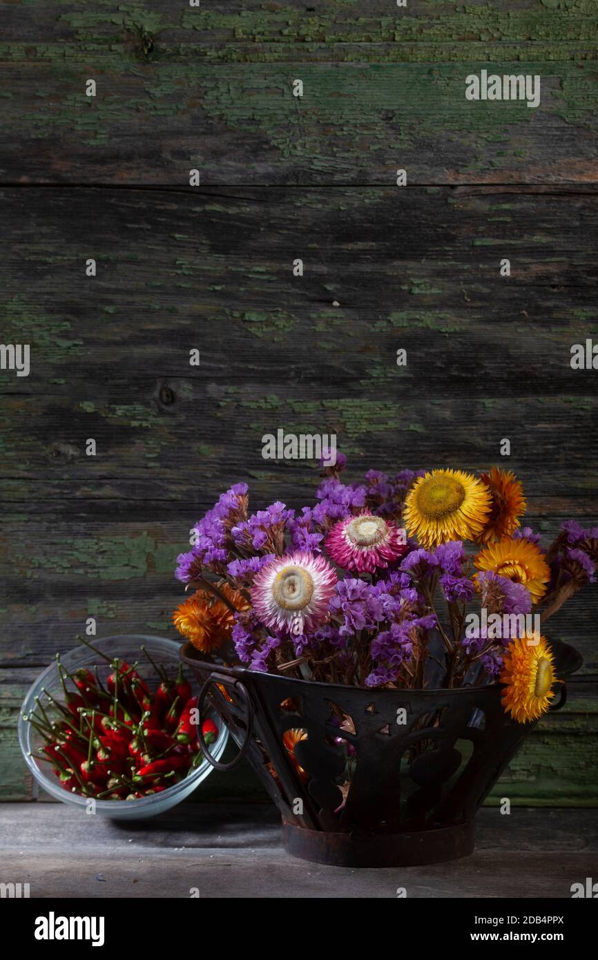 Stillleben Nahaufnahme Foto von Bouquet von lebendige getrocknet Blumen und Paprika auf Holzhintergrund Stockfoto