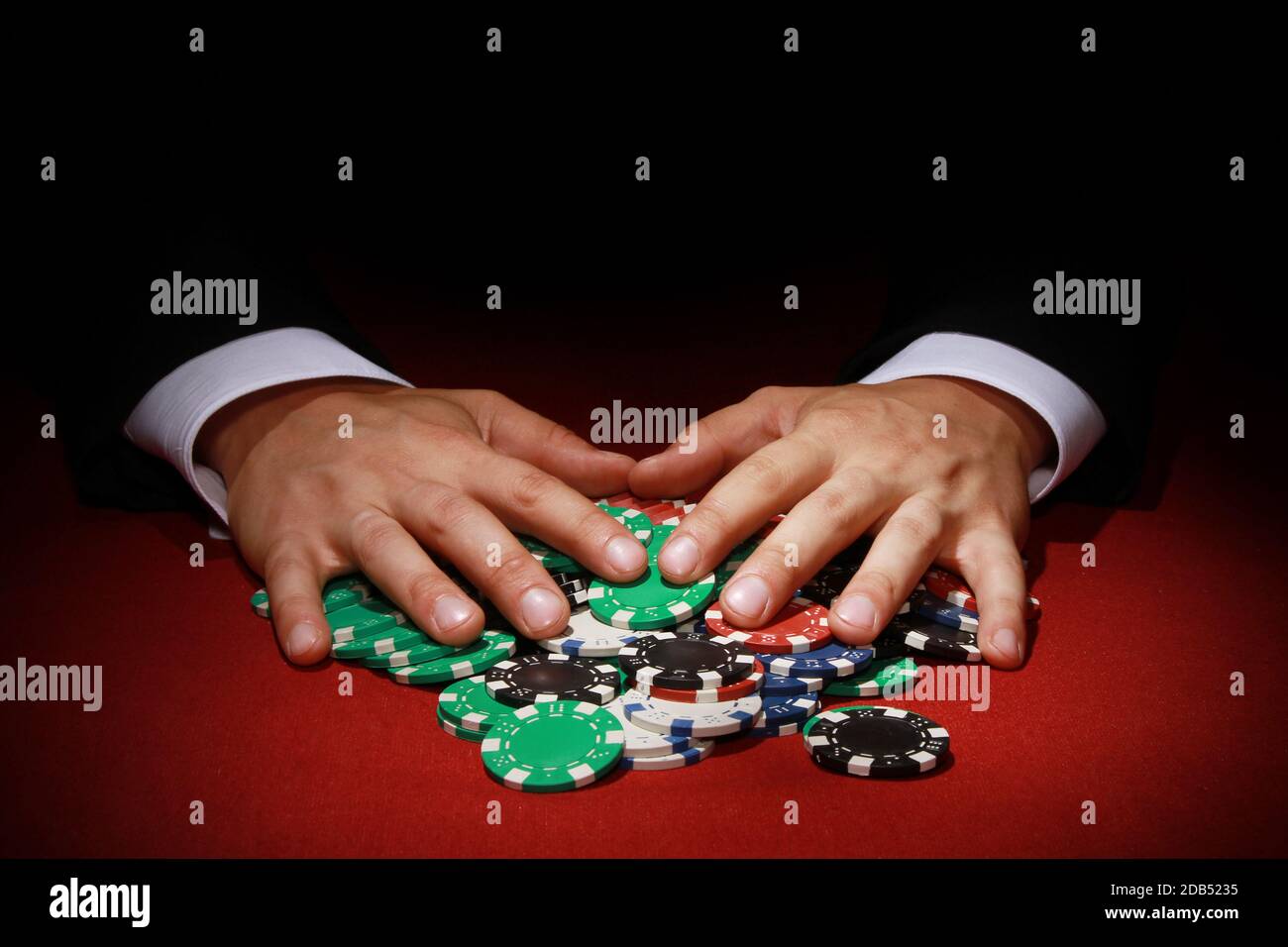Eine Nahaufnahme eines Pokerspielers, der einen großen nimmt Stapel von Poker-Chips Stockfoto