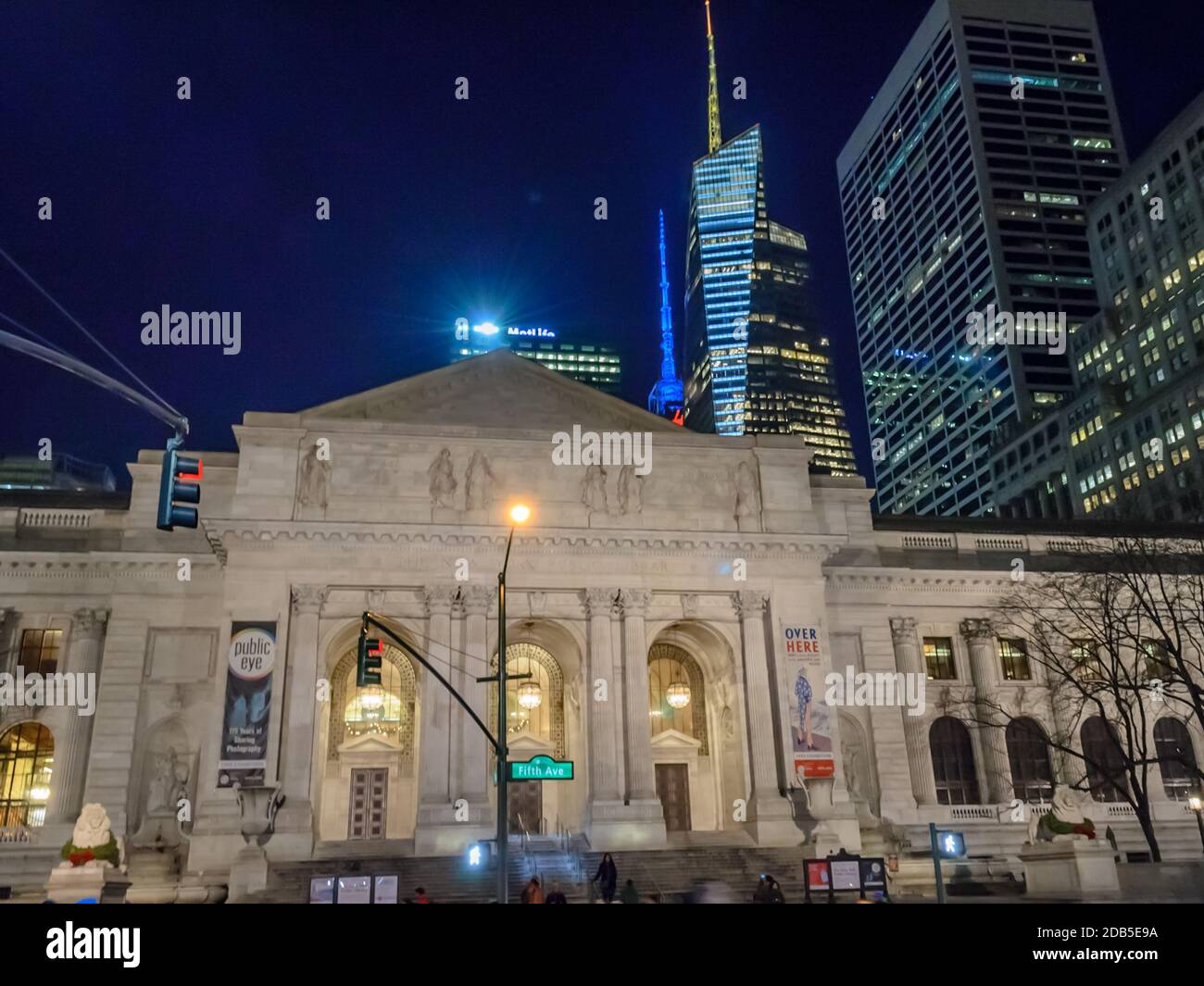 Fassade der New York City Public Library bei Nacht. Futuristische Manhattan Wolkenkratzer im Hintergrund Stockfoto