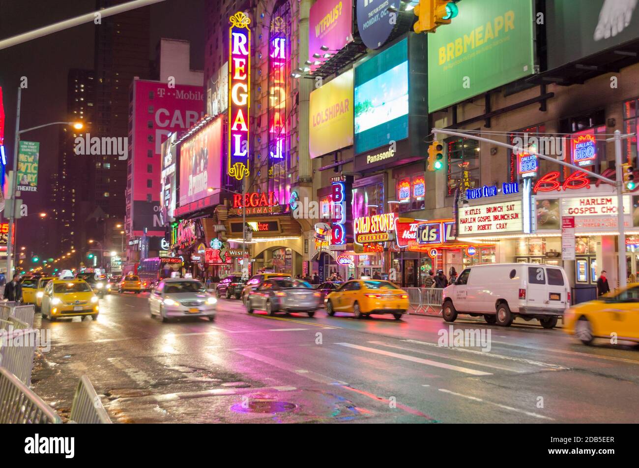 Typische NYC Manhattan Avenue in der Nähe des Times Square. Fahrzeuge, die auf der Straße, Broadway-Theater, Plakatwände, Neonlichter und LED-Bildschirme bewegen. Stockfoto