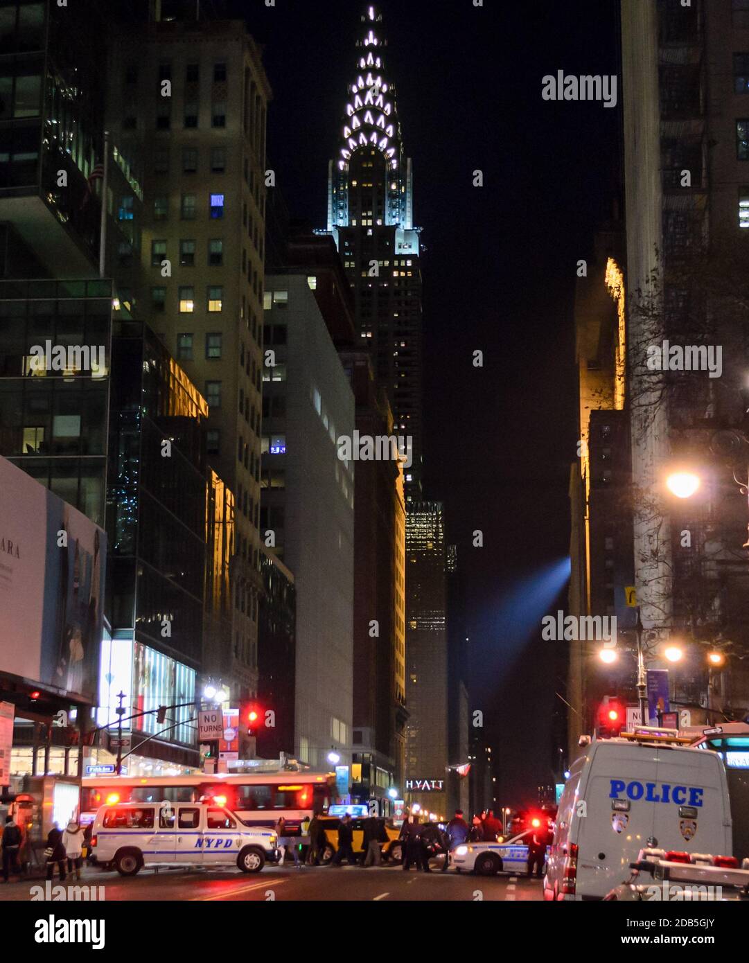 NYPD Polizeifahrzeuge und Polizisten blockierten die Straße wegen der Silvesterfeiern am Times Square, New York. Die Leute warten auf den Pass. Chrysler Building Stockfoto