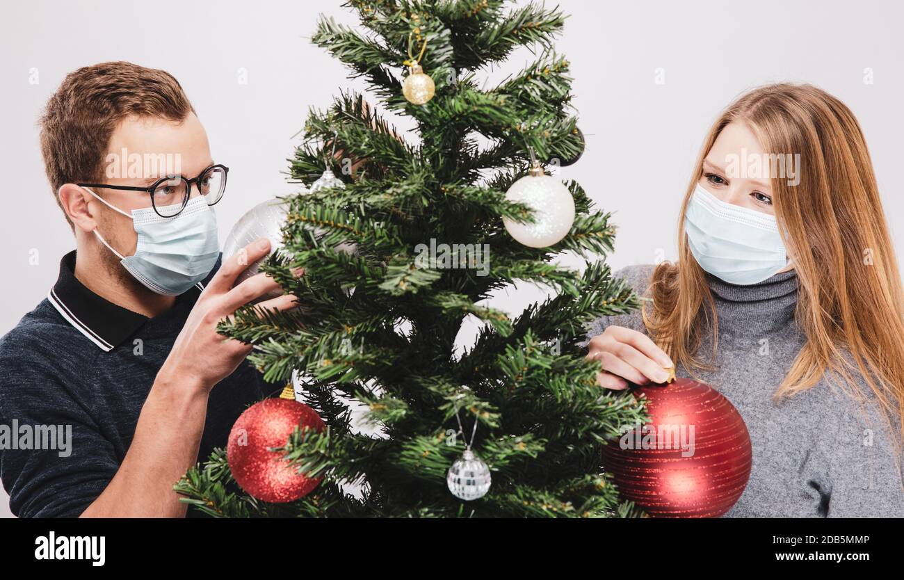 Paar Dekoration der Weihnachtsbaum trägt covid-19 Gesichtsmaske Stockfoto