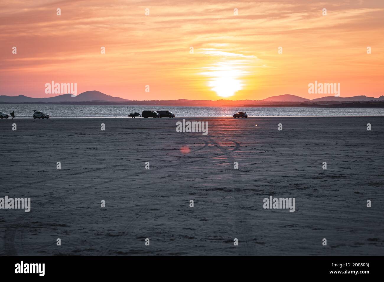 Warmer Sonnenuntergang über dem Strand von Black Rock Sands in North Wales, Großbritannien Stockfoto
