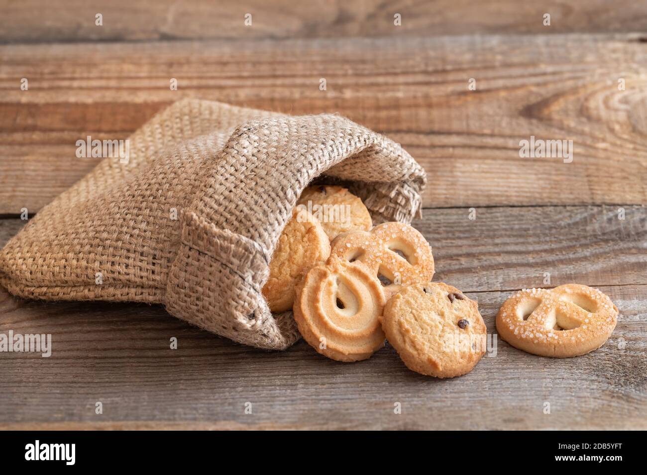 Butterkekse in Burlapentasche auf Holztisch Stockfoto