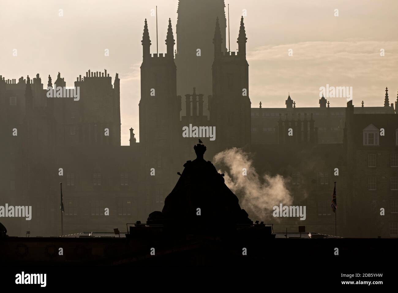 Morgennebel mit Königin Victoria auf der Royal Scottish Academy mit den Türmen des General Assembly Gebäudes im Hintergrund, Edinburgh. Stockfoto
