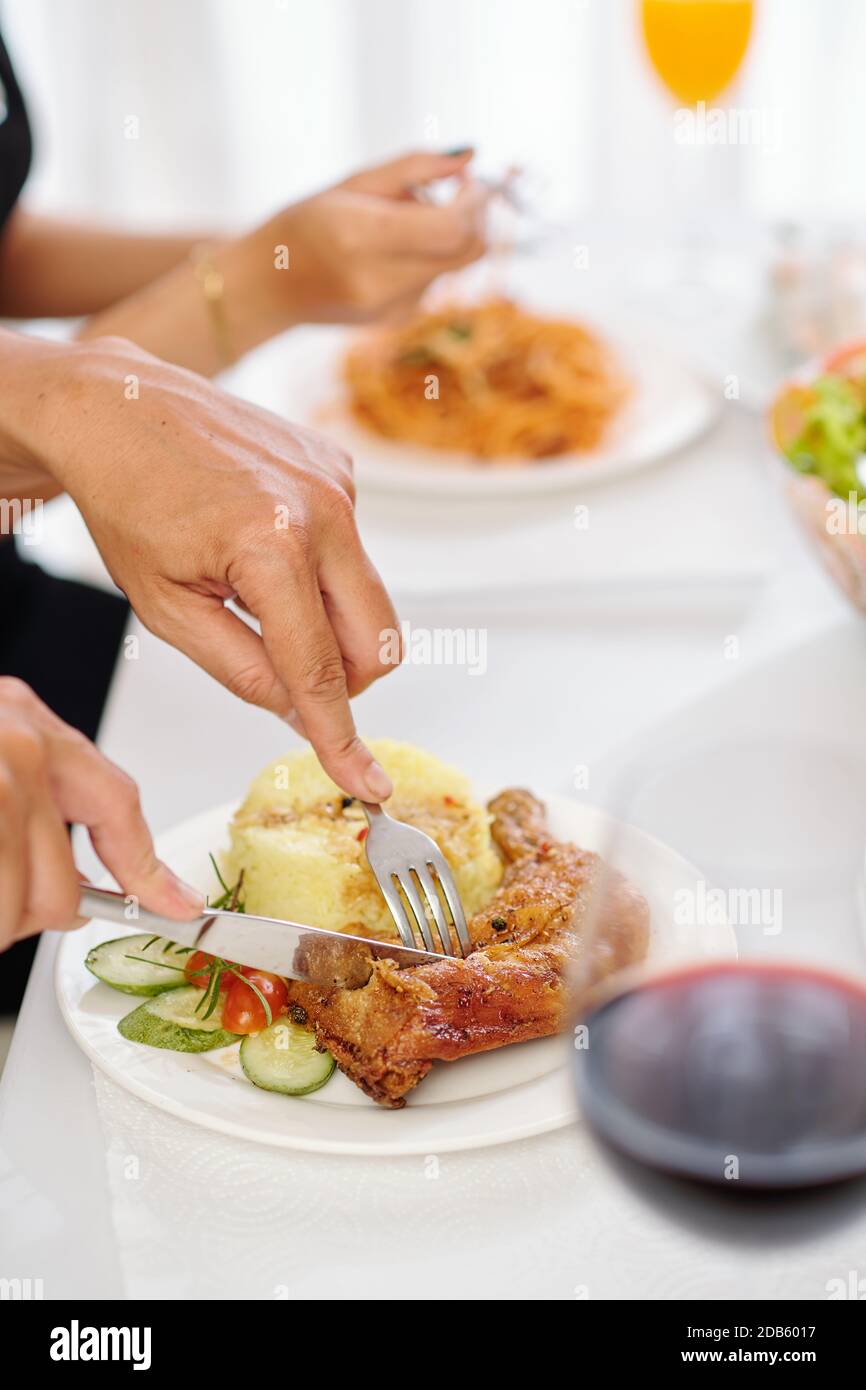 Frau essen gebratenes Huhn mit Kartoffeln Stockfoto